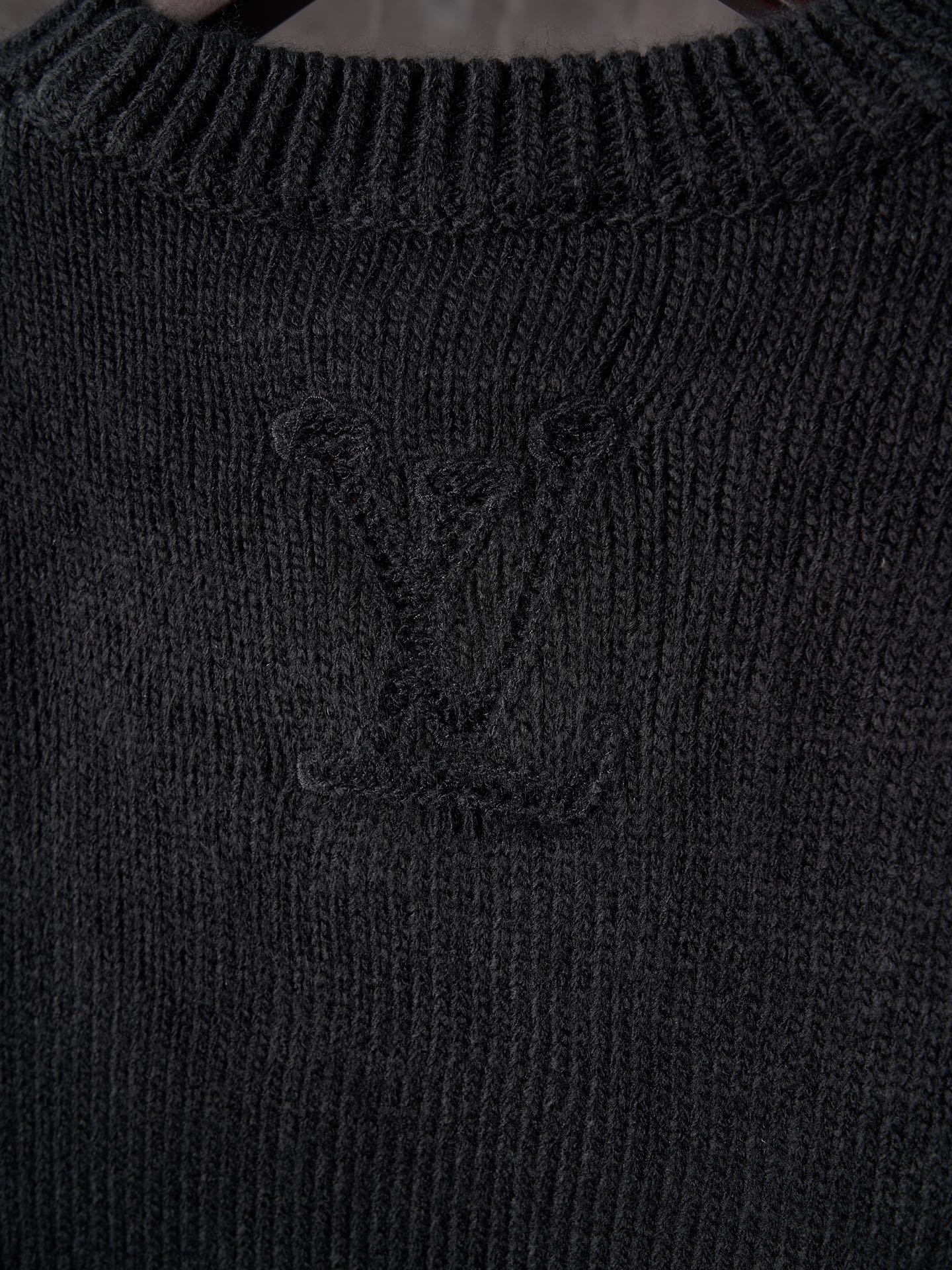 Black knit sweater with central monogram detail and ribbed collar