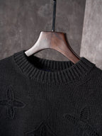 Black knit crewneck sweater neckline and ribbed collar on wooden hanger