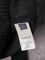 Black knit sweater care label tag on hanger
