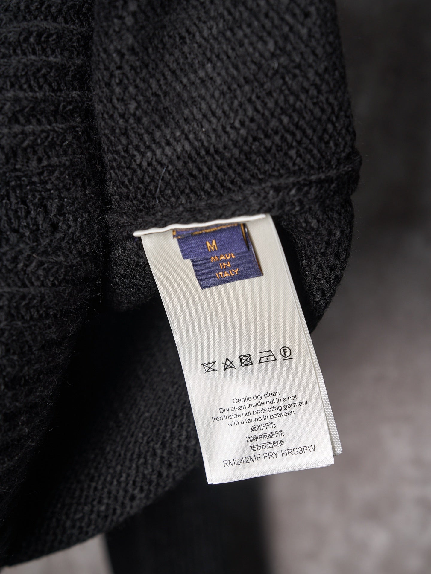 Black knit sweater care label tag on hanger