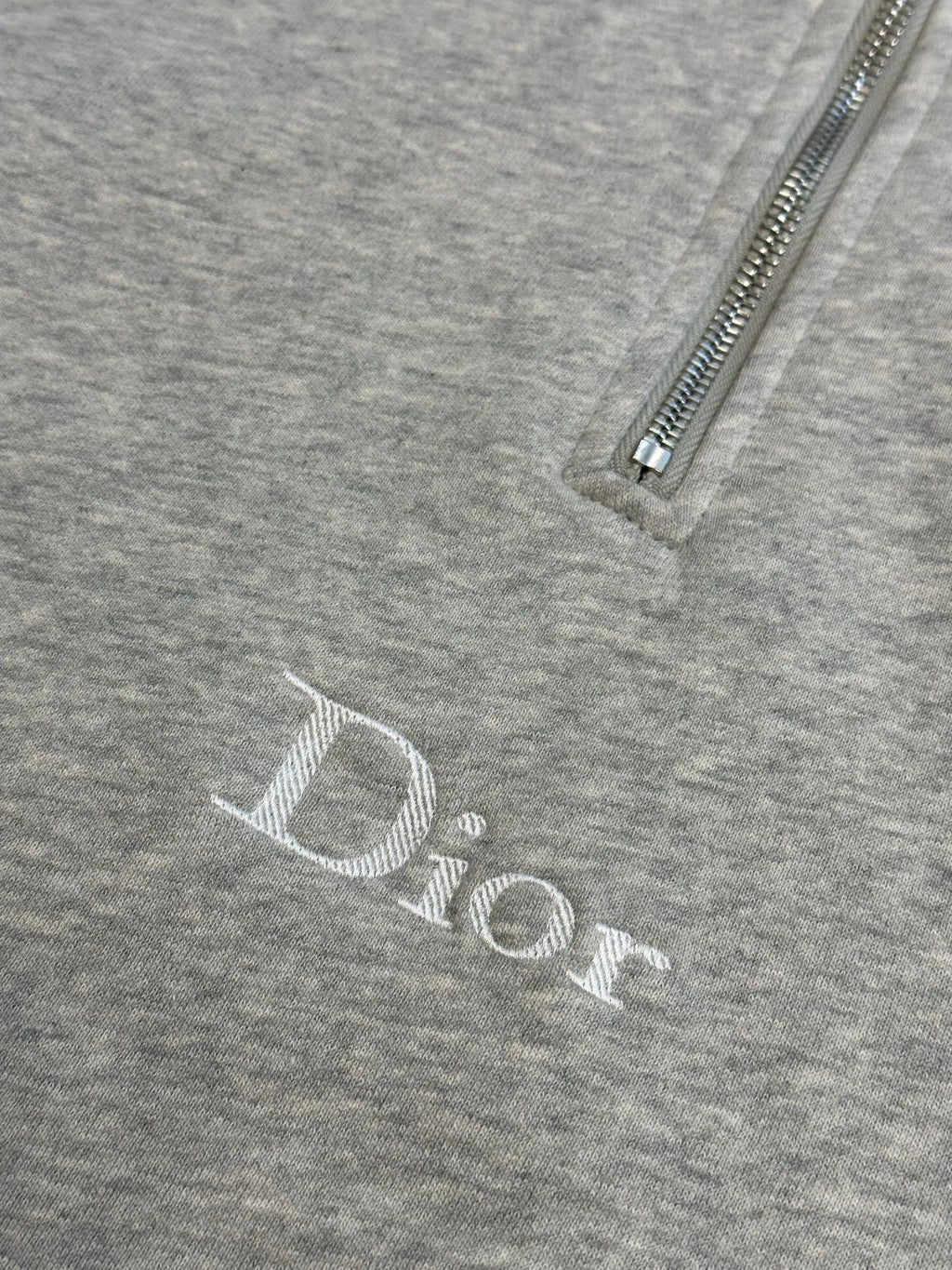 Dior logo print on heather gray hoodie fabric near zipper