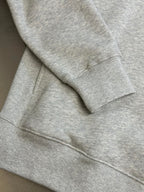 Light gray heather sweatshirt sleeve cuff and curved hem seam