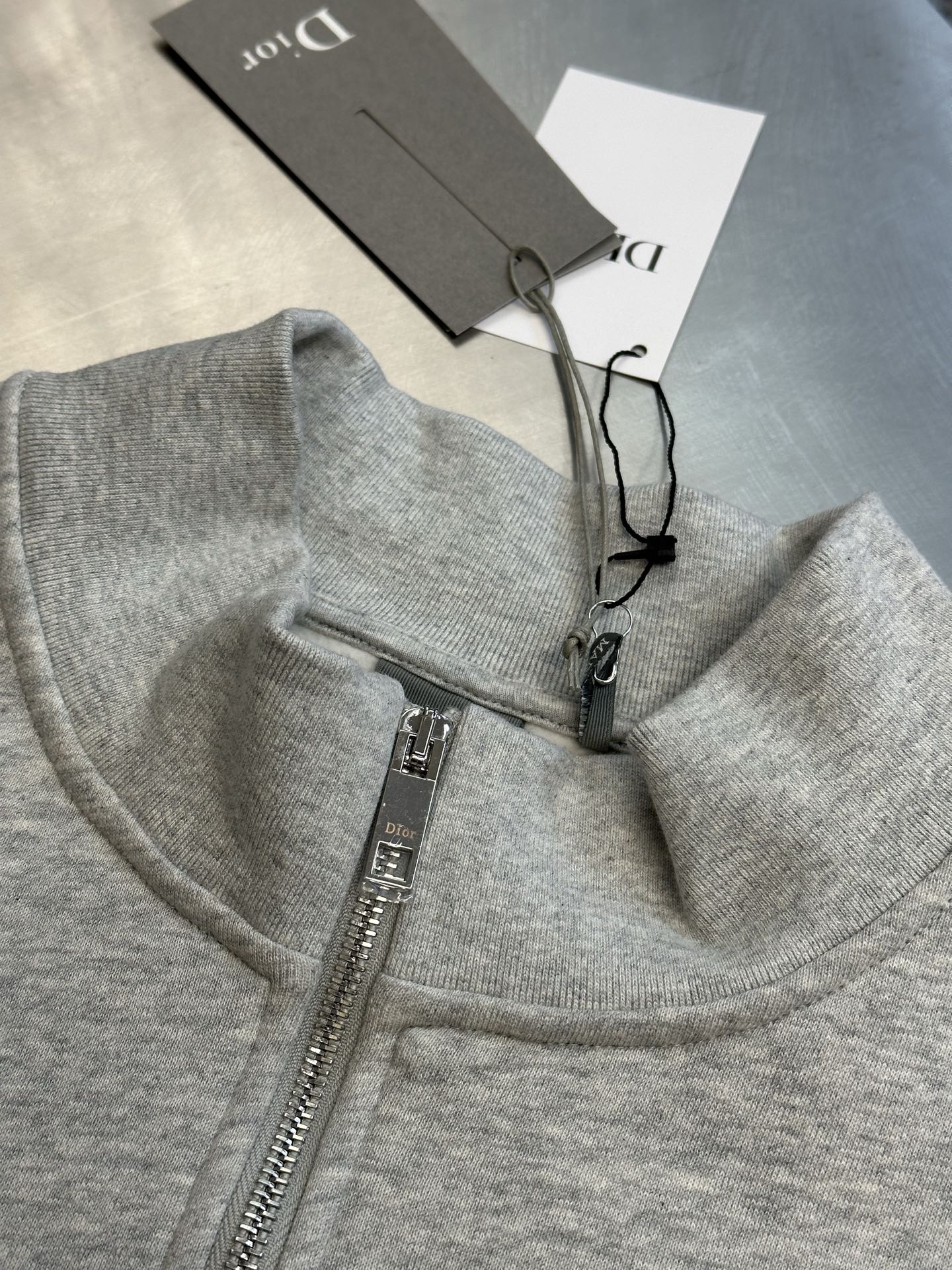 Light gray heather half-zip sweatshirt with front zipper and inner care tags