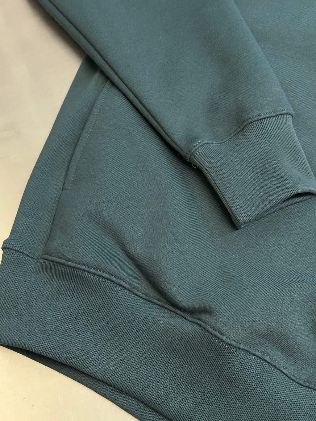 Teal Dior sweatshirt hem and ribbed cuffs with soft knit texture