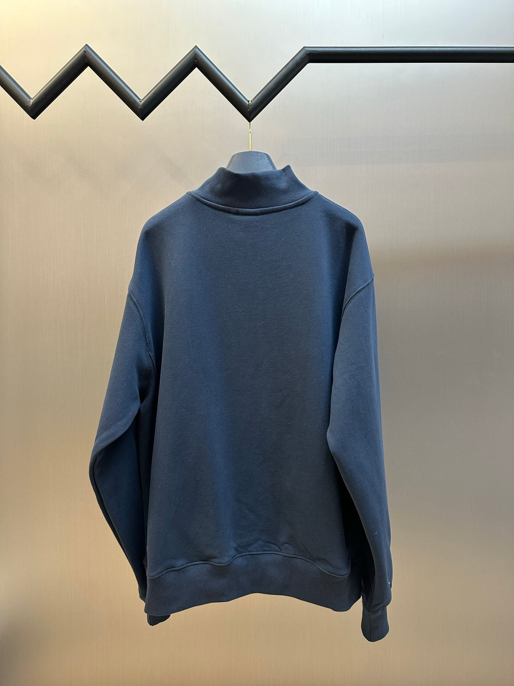 Dark blue Dior quarter-zip hoodie back view on hanger