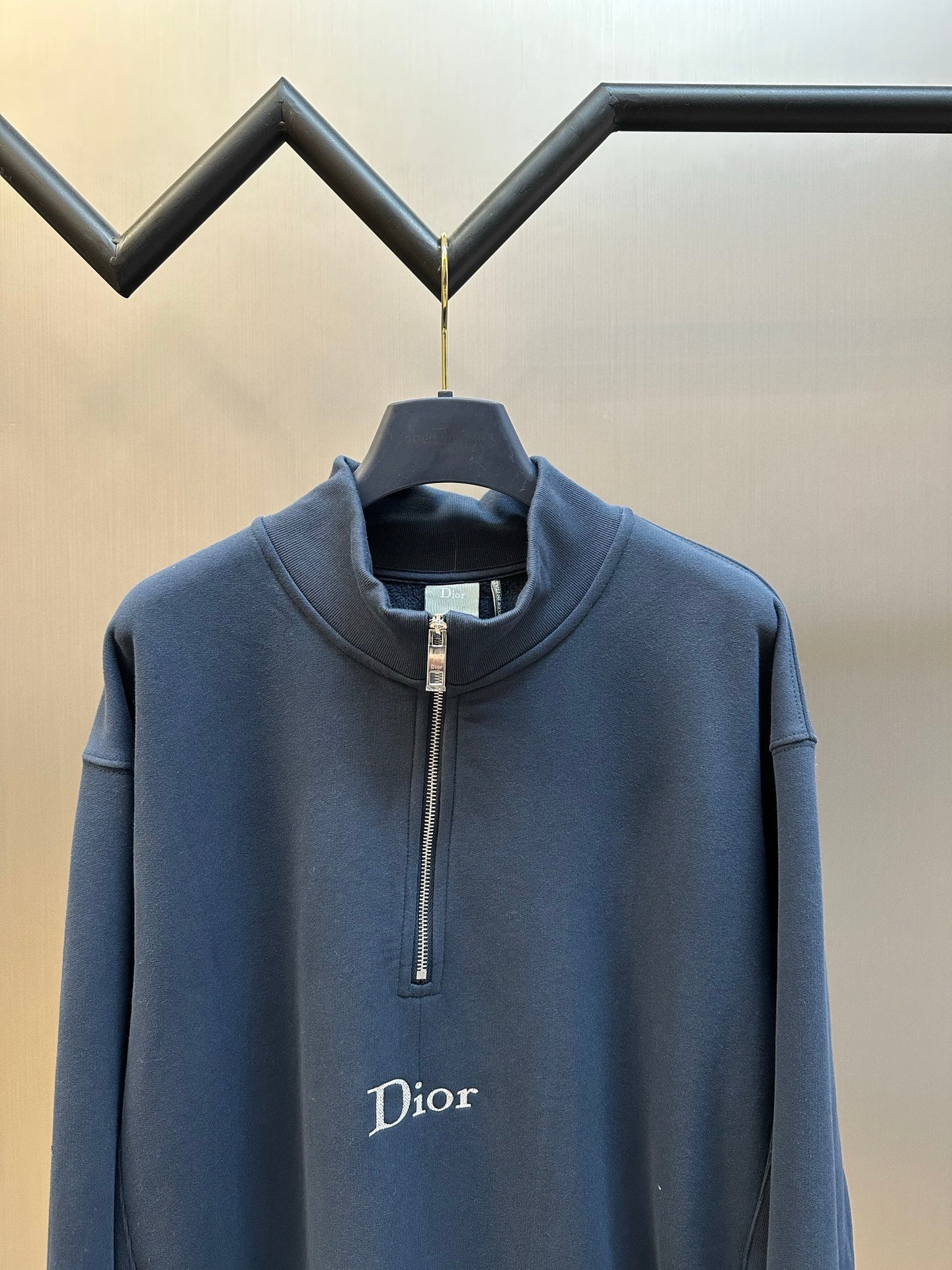 Dark blue Dior quarter-zip hoodie close-up with stand collar and chest logo