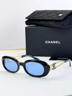 Designer round glasses, black frame with blue lenses, gold logo detail
