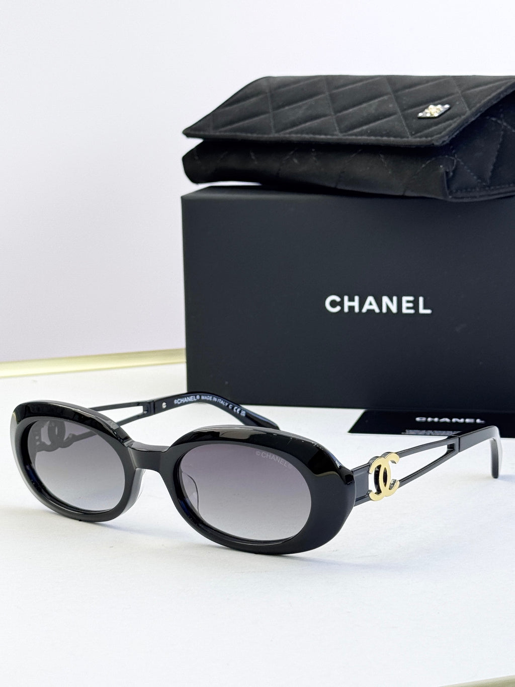 Designer round glasses, black frame with gold-tone hardware, clear lenses