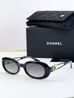 Designer round glasses, black frame with gold-tone hardware, clear lenses