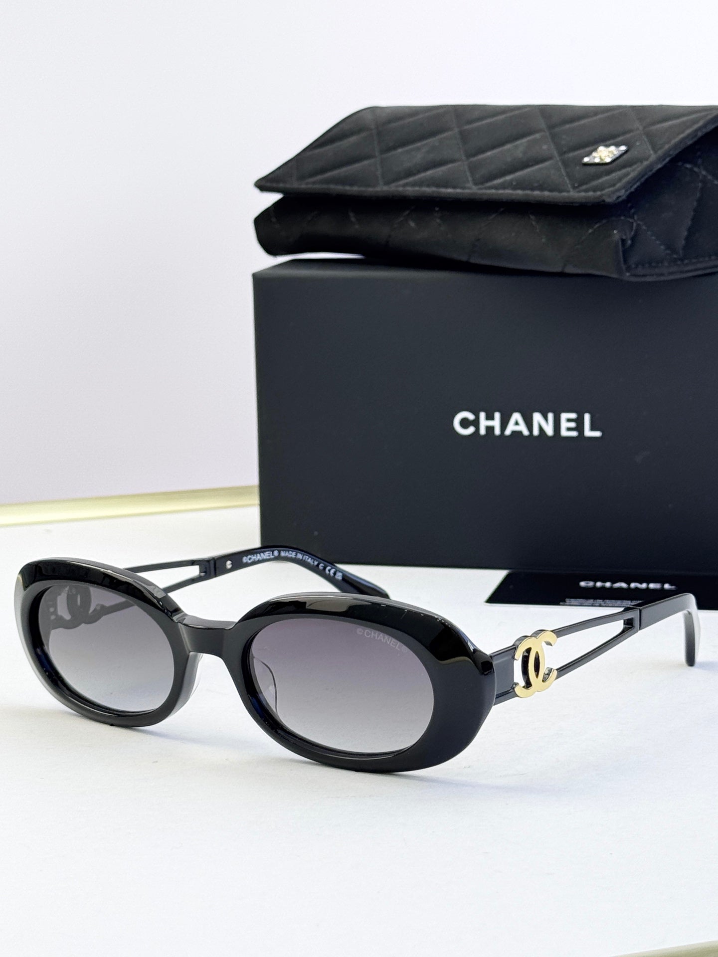 Designer round glasses, black frame with gold-tone hardware, clear lenses