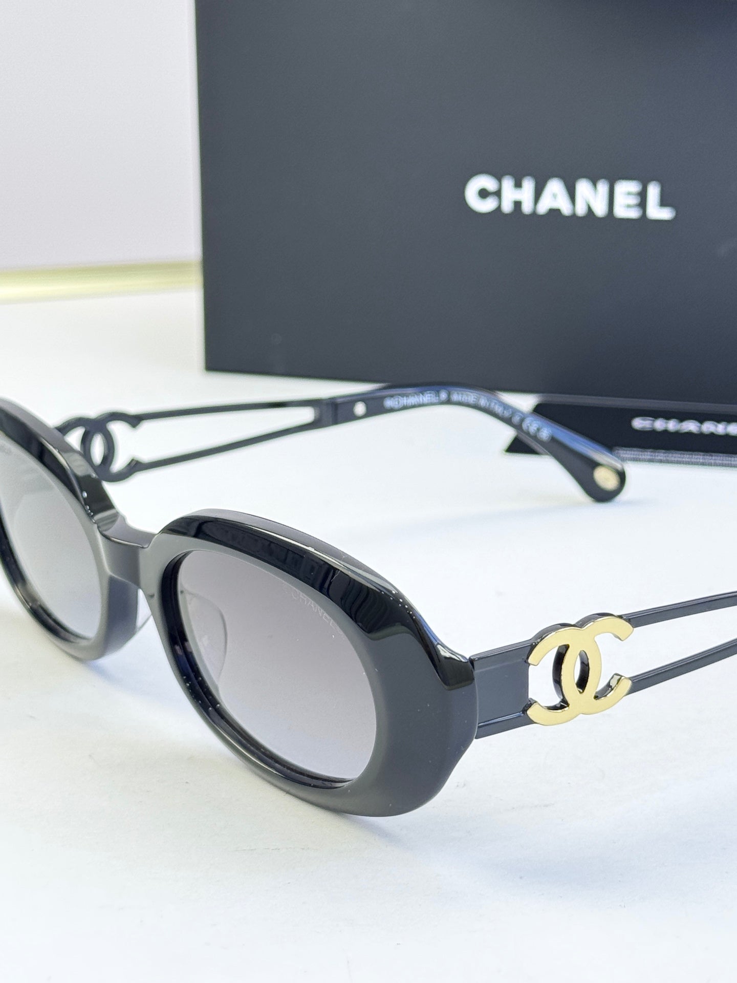 Designer round glasses, black frame with gold CC detail, dark lenses