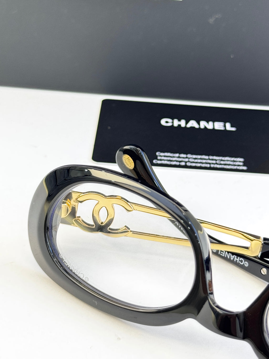 Black oval eyeglasses with gold-tone double-C temple emblem