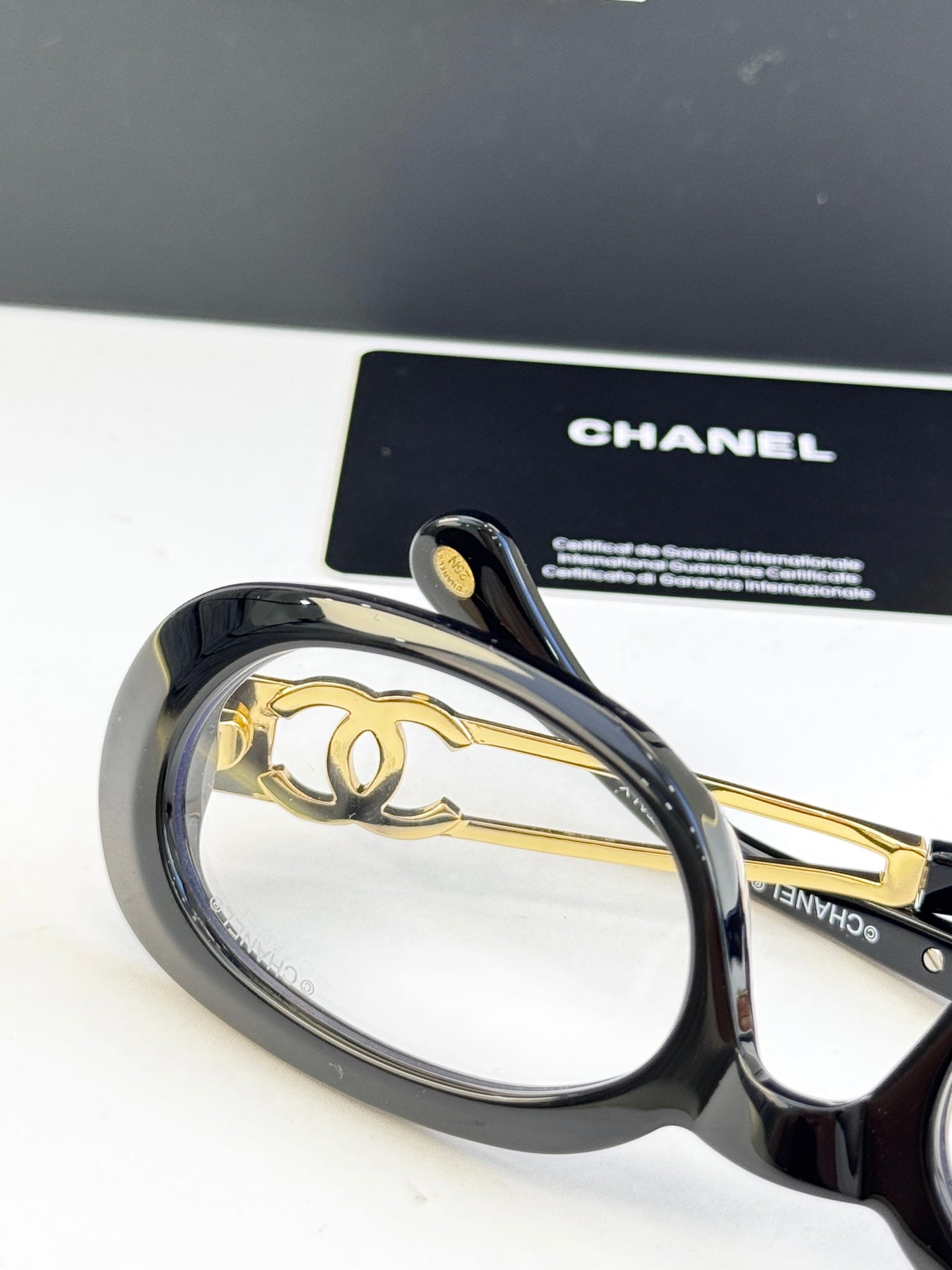 Black oval eyeglasses with gold-tone double-C temple emblem