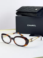 Tortoiseshell oval eyeglasses with gold-tone double-C temple detail
