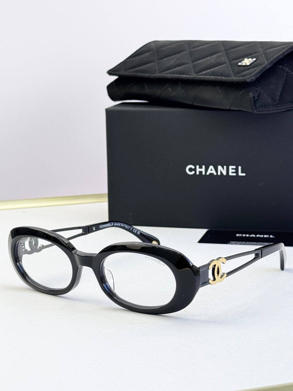 Black oval eyeglasses with gold-tone double-C temple detail
