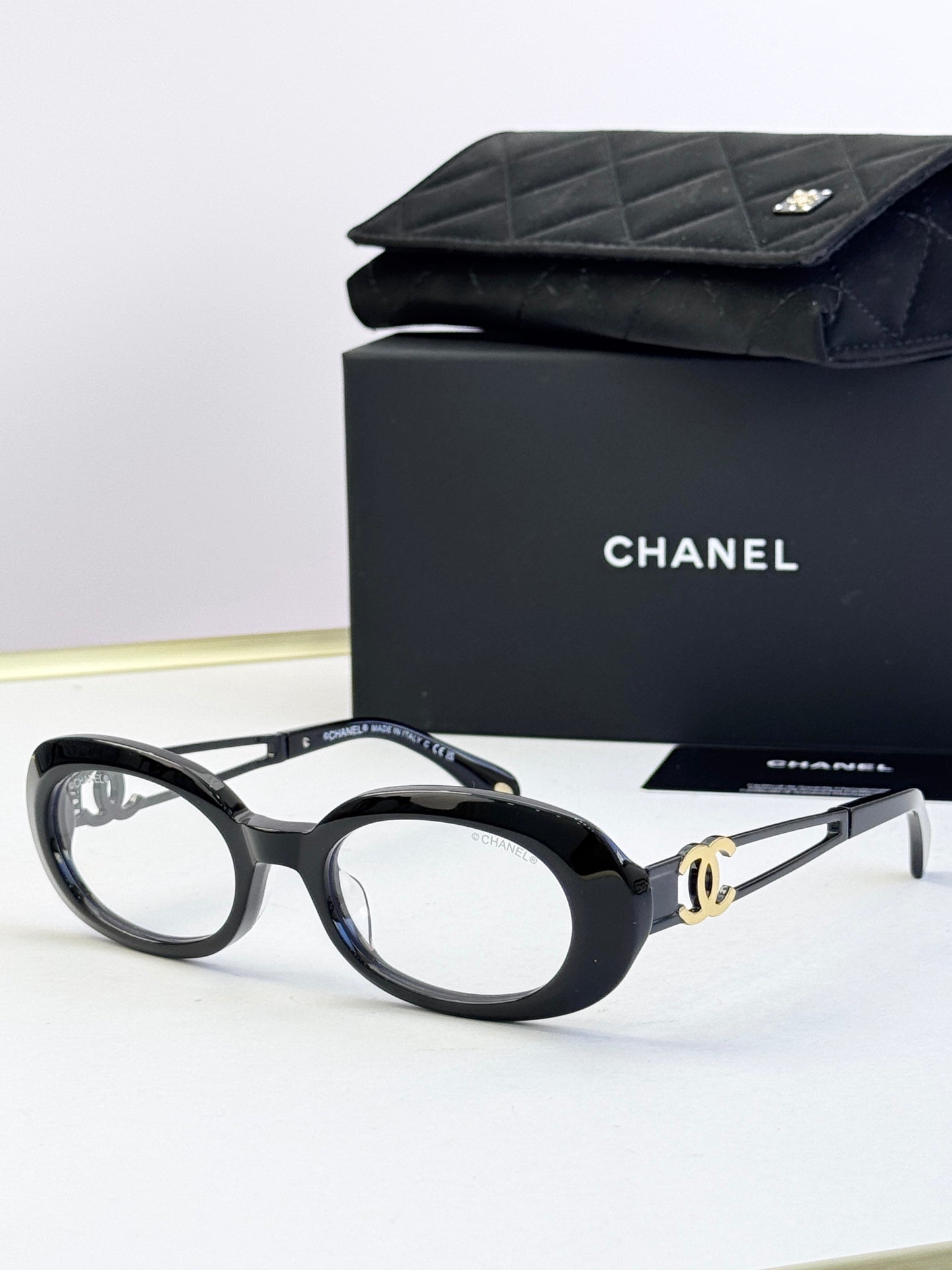 Black oval eyeglasses with gold-tone double-C temple detail