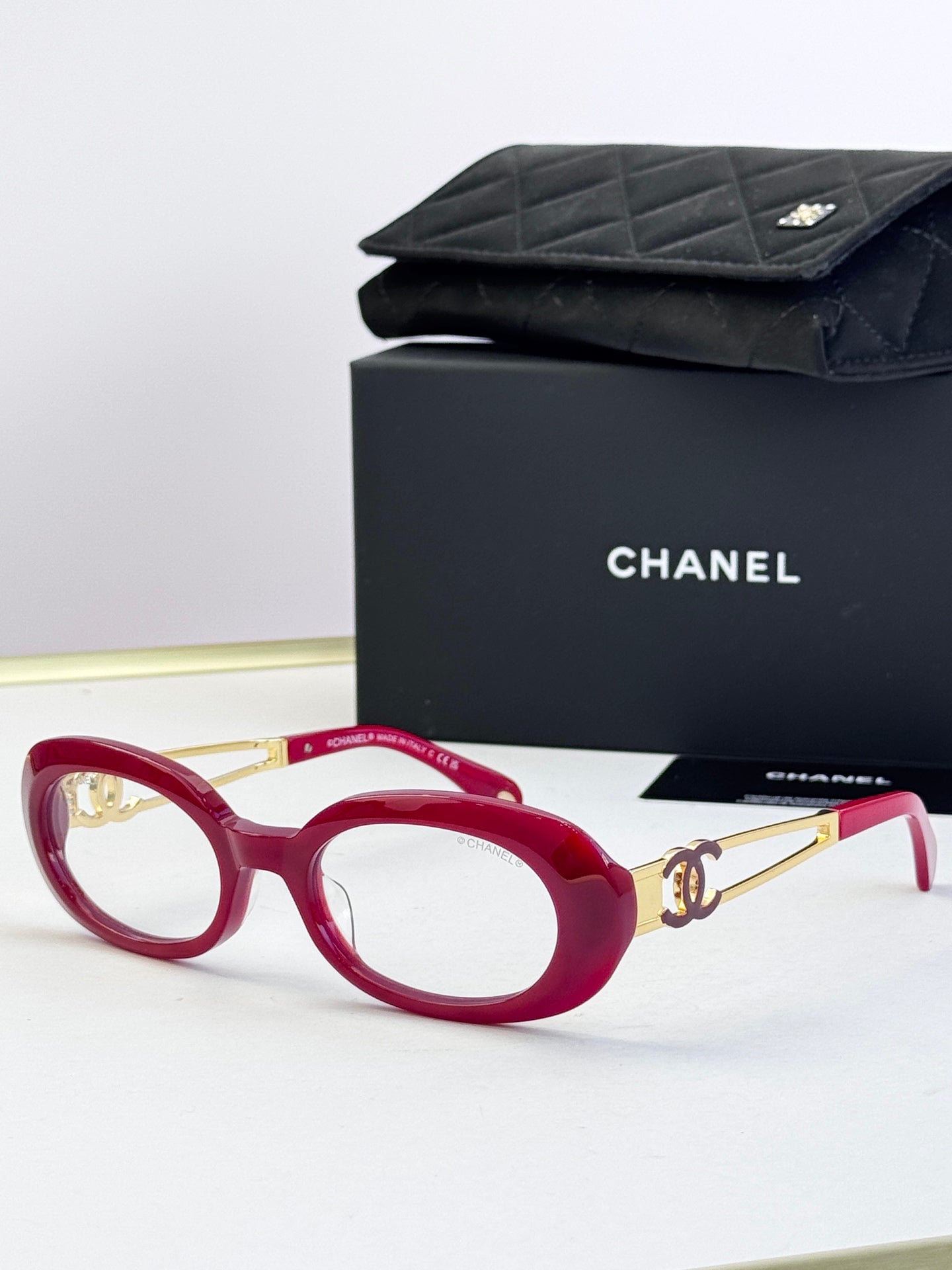 Red round-oval eyeglasses with gold-tone double-C temple detail