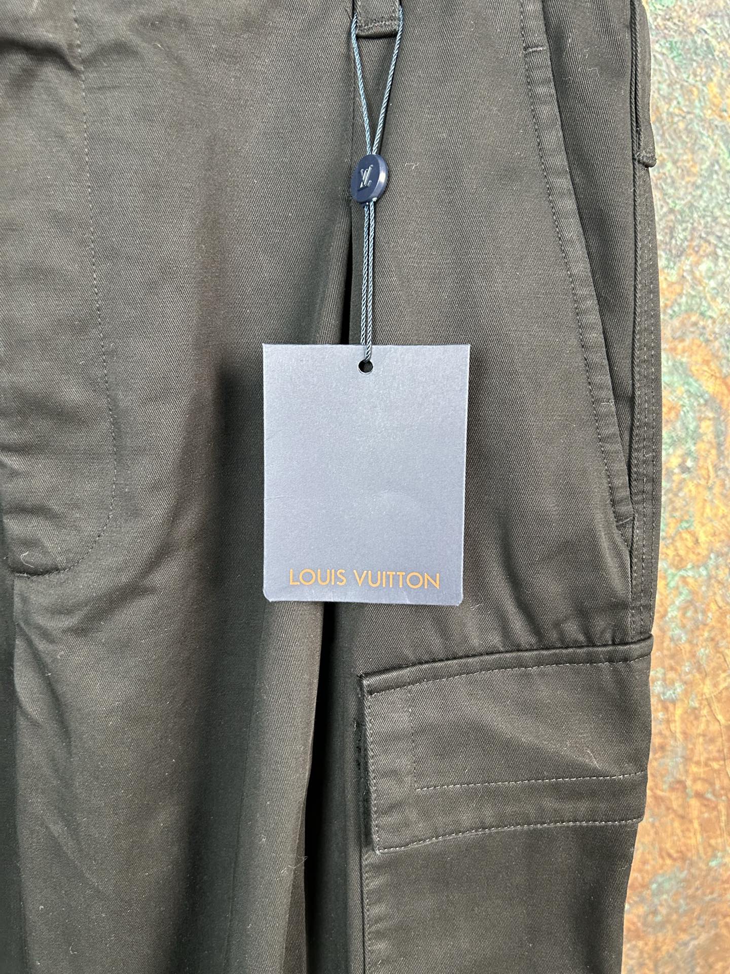 Olive pants with Louis Vuitton hang tag and side pocket panel