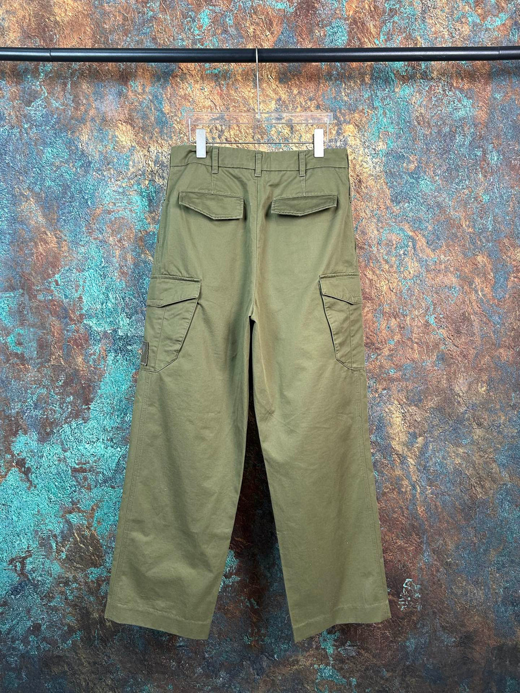 Olive utility pants with two flap pockets, visible belt loops and straight legs