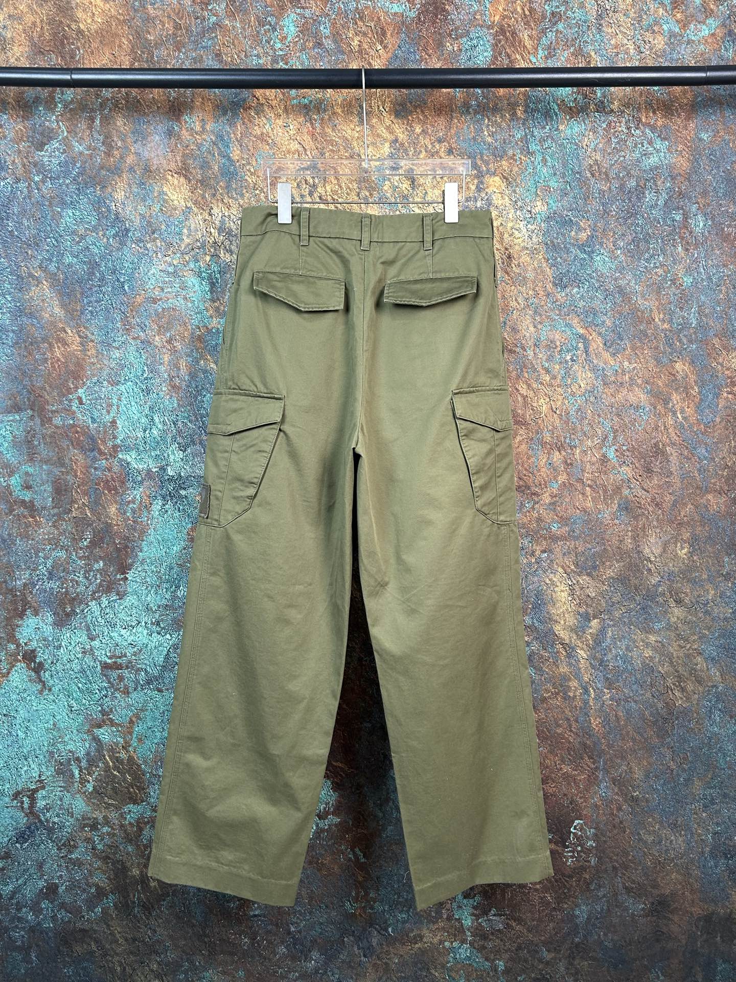 Olive utility pants with two flap pockets, visible belt loops and straight legs