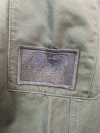 Olive pants pocket with stitched fabric patch detail