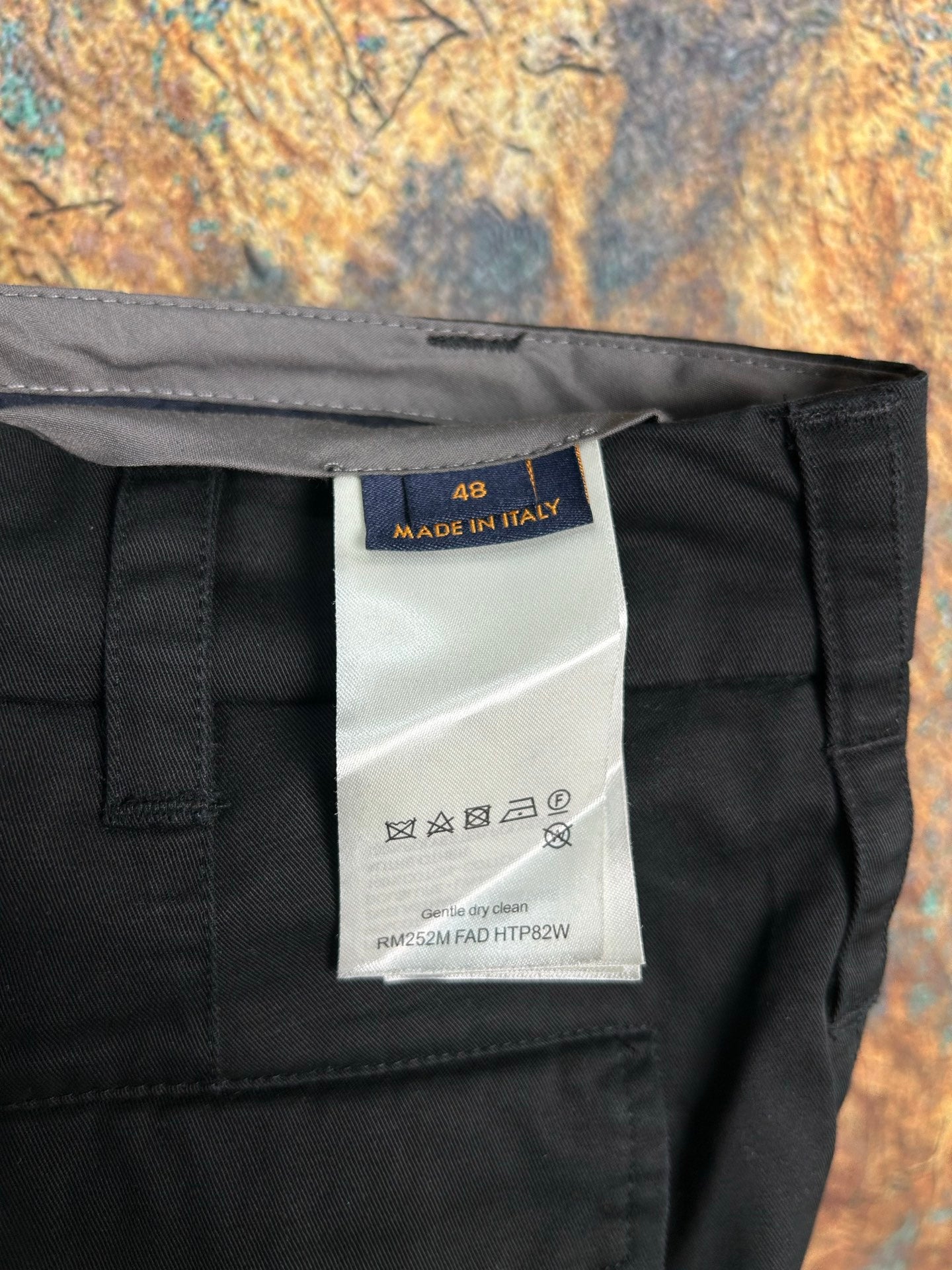 Black pants care label showing size 48 and Made in Italy