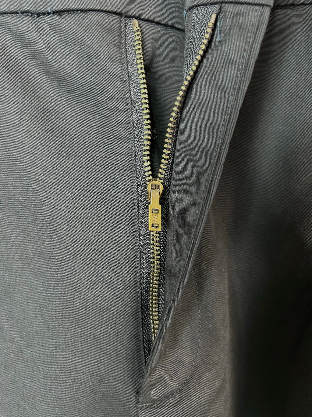 Black cargo pants with gold-tone zipper and button fly
