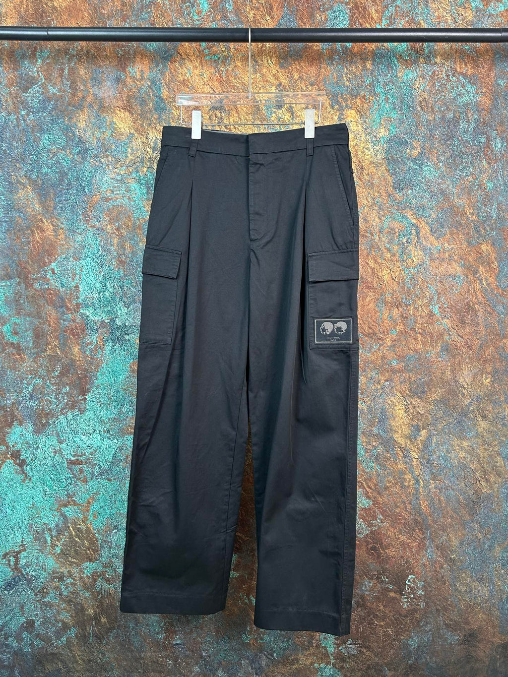 Black cargo pants with flap side pockets and adjustable waistband tabs