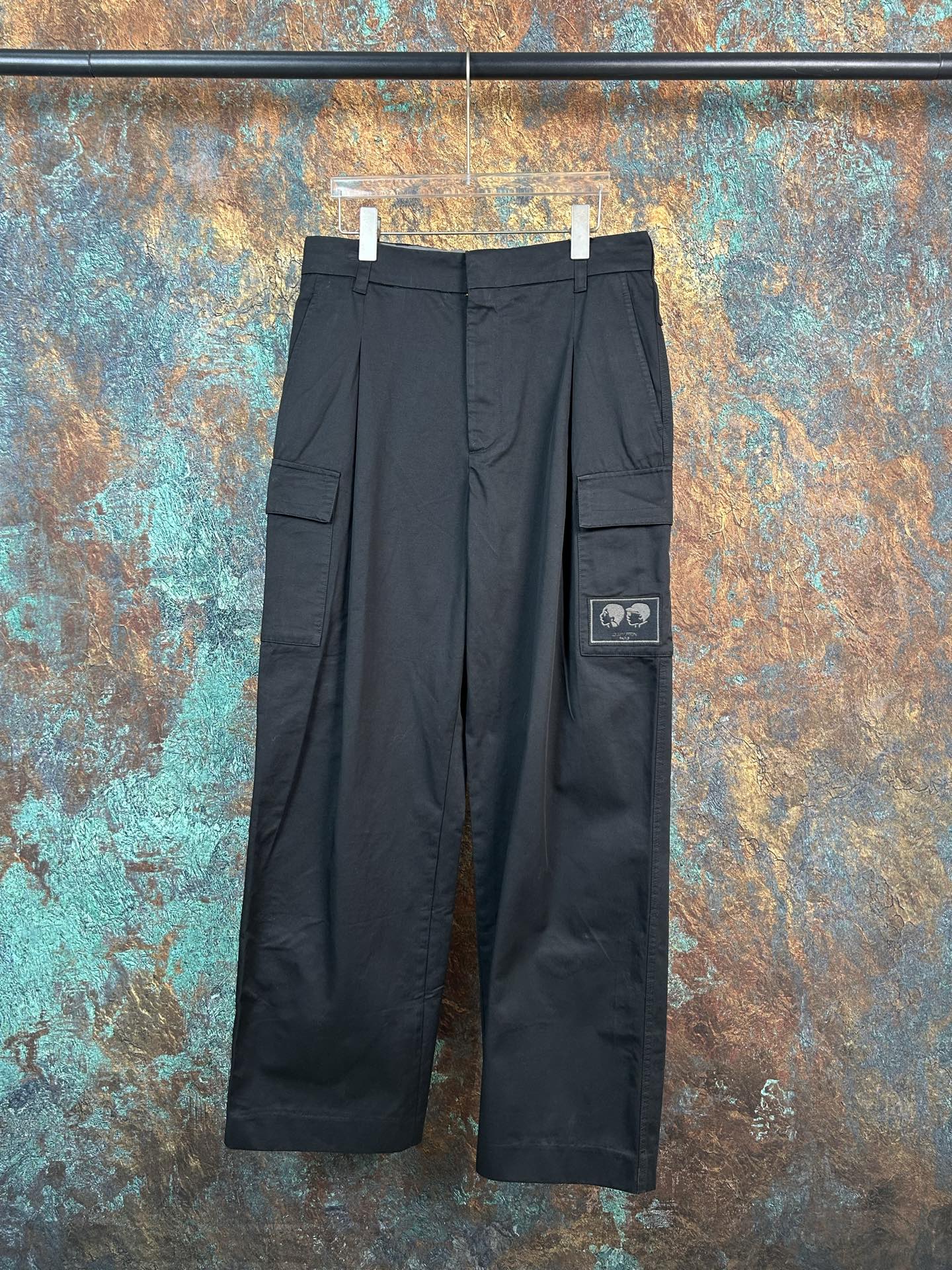 Black cargo pants with flap side pockets and adjustable waistband tabs