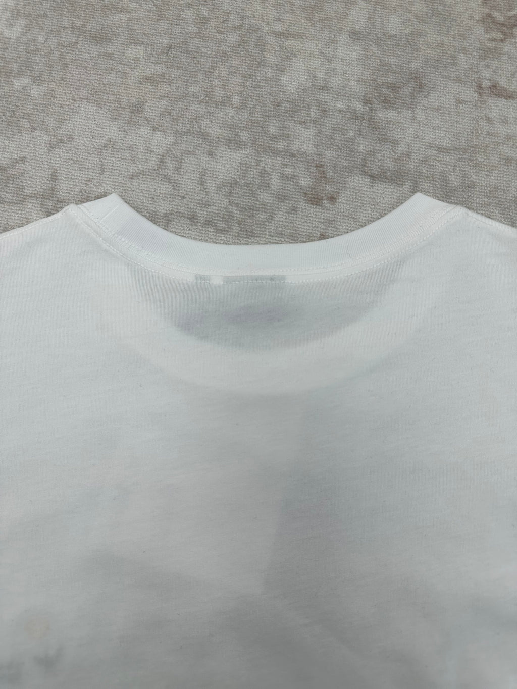 White T-shirt back neckline and upper back seam detail.