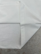 White T-shirt hem and side seam with stitching detail.