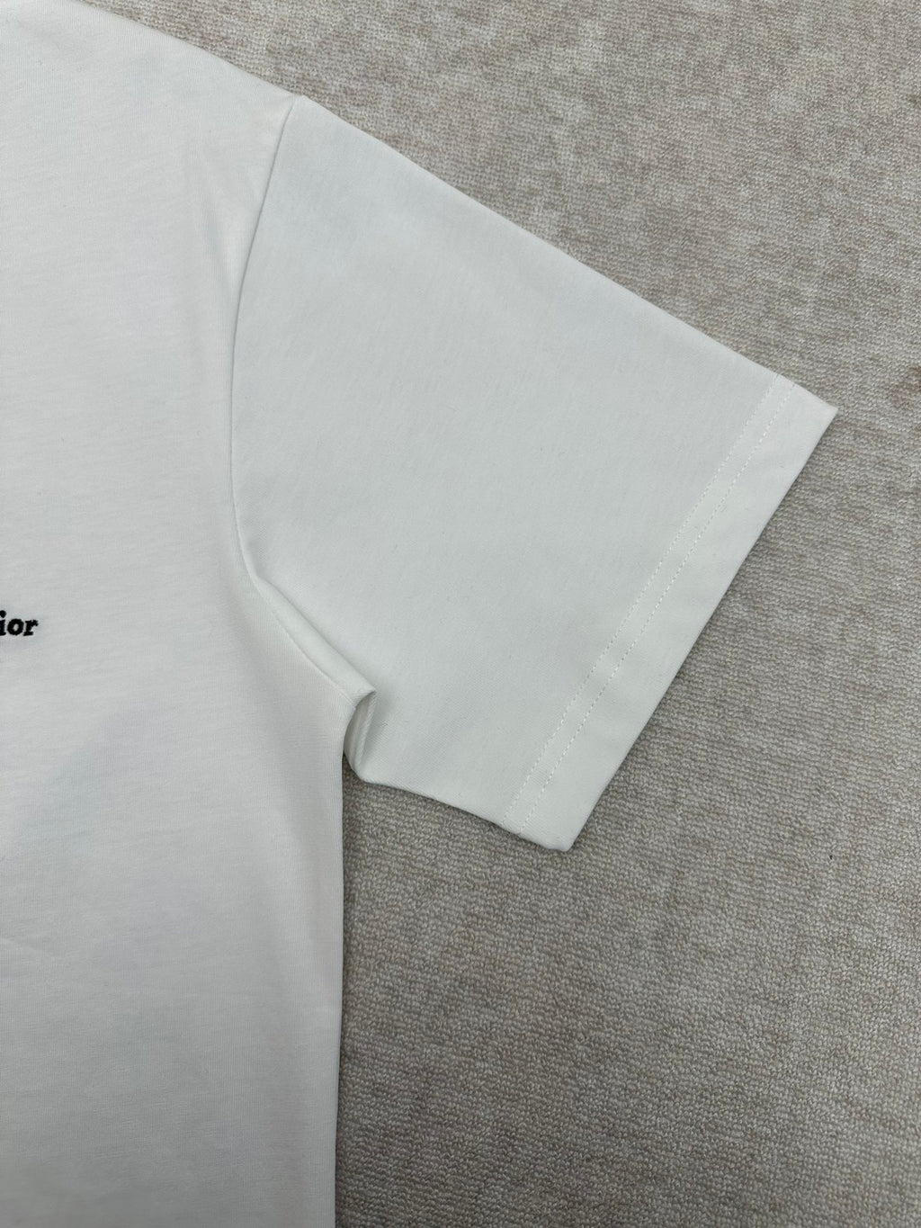 White T-shirt sleeve and side seam detail.