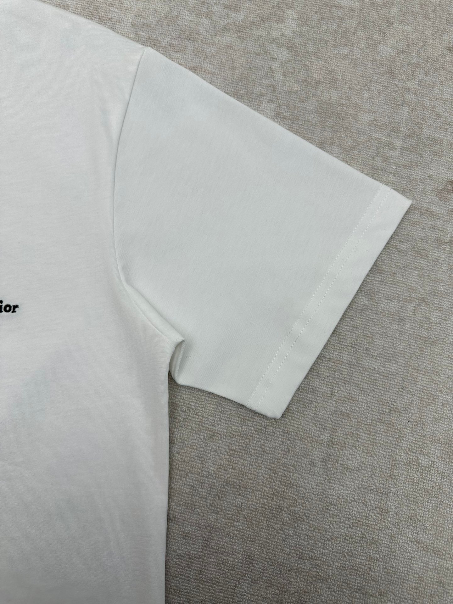 White T-shirt sleeve and side seam detail.