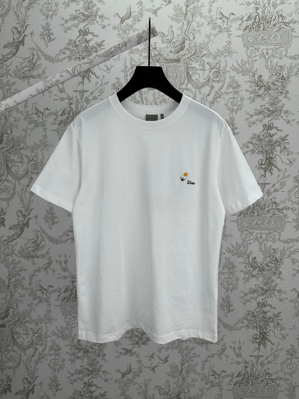 White crewneck T-shirt with small daisy logo embroidery on left chest.
