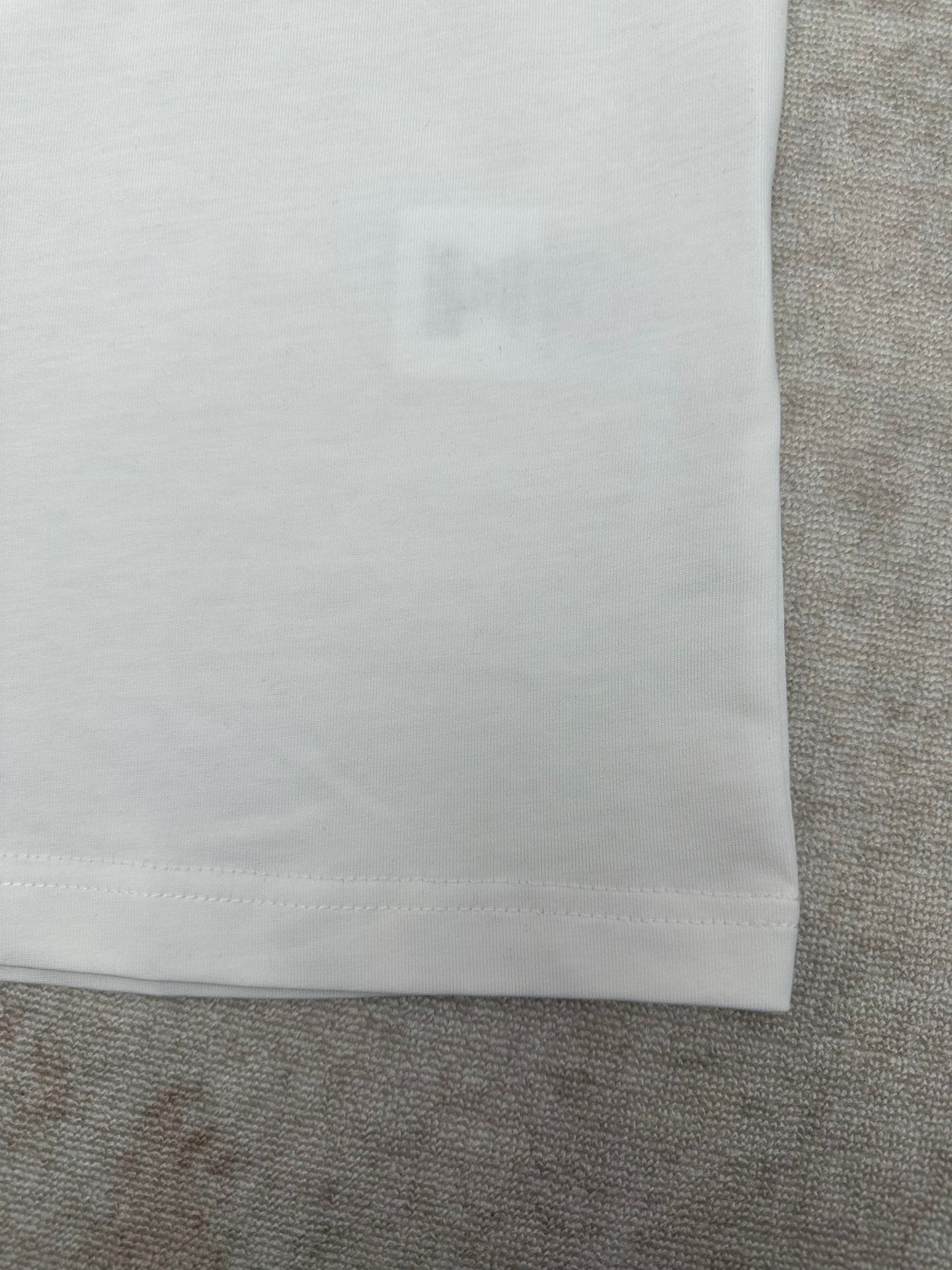 White T-shirt hem detail with straight bottom seam.