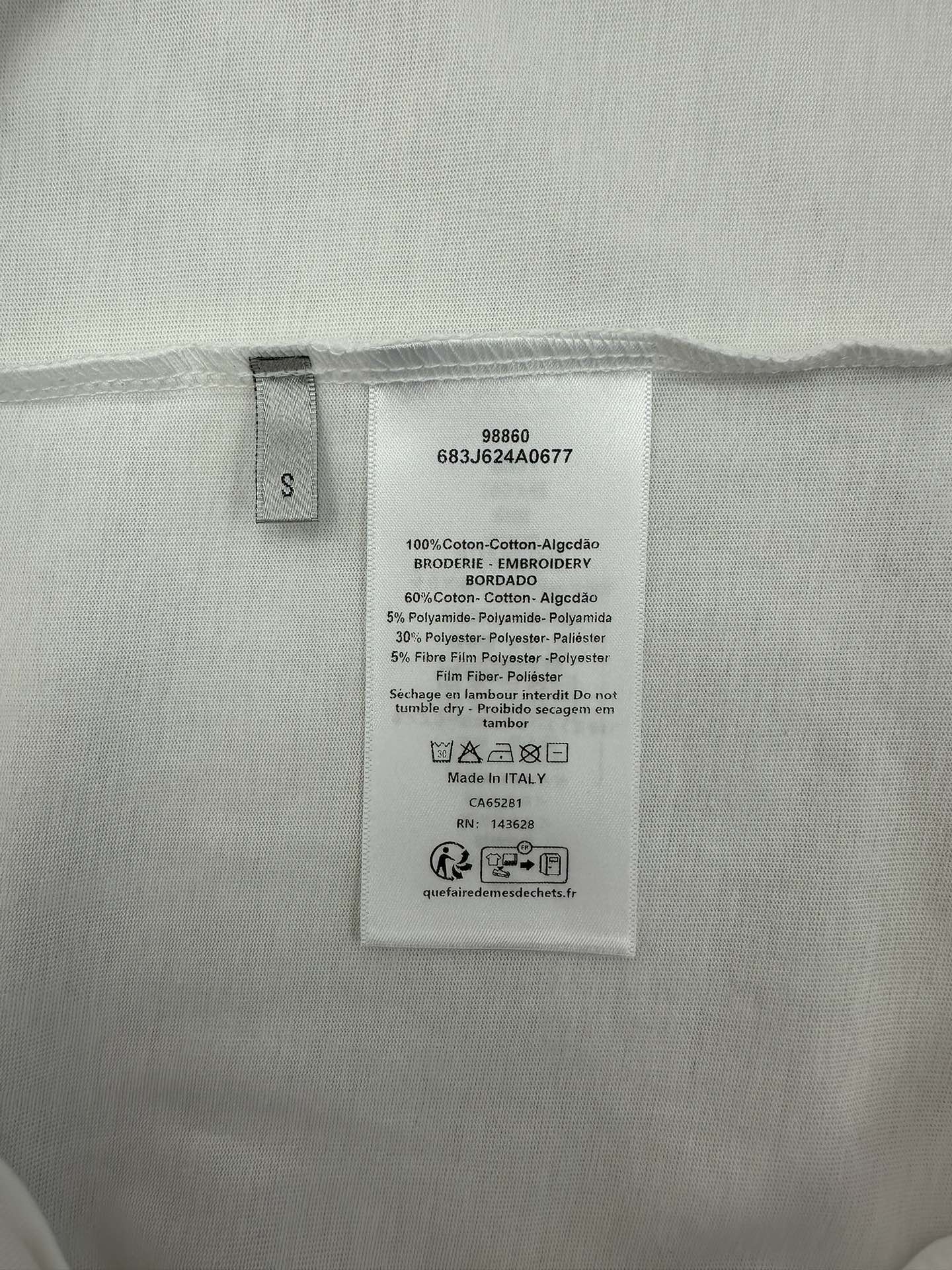 Inside size and care label on white T-shirt.