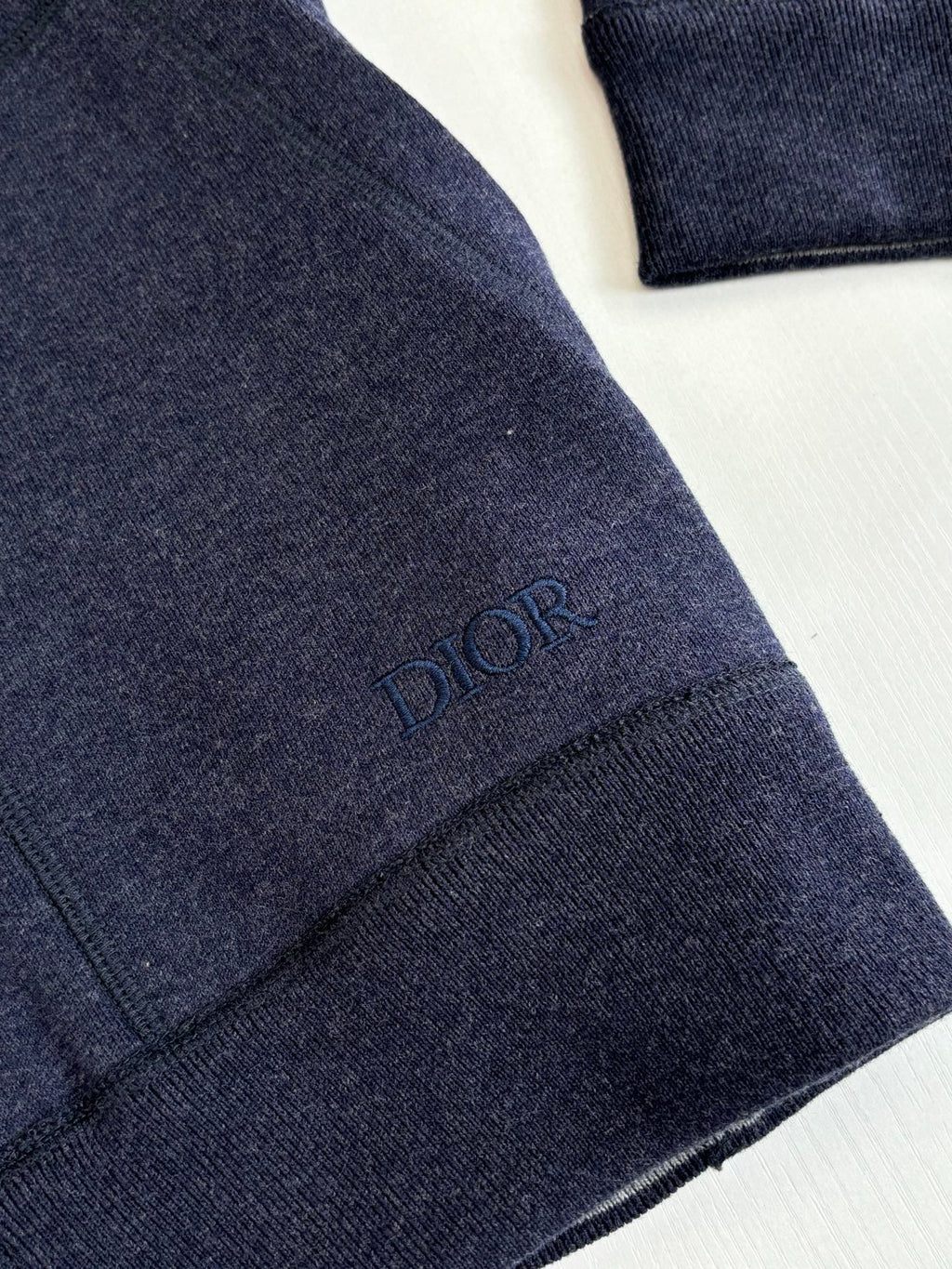Dior navy hoodie sleeve with embroidered “DIOR” mark on cuff