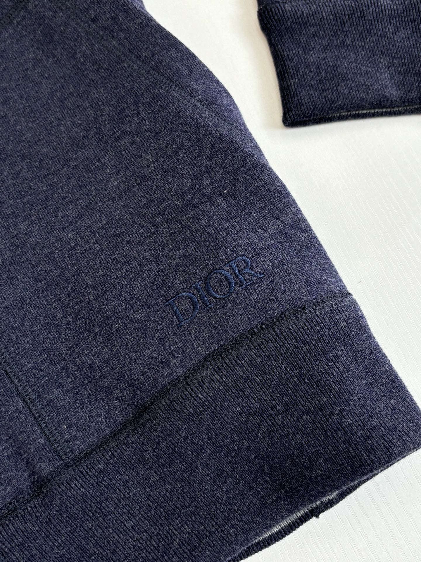 Dior navy hoodie sleeve with embroidered “DIOR” mark on cuff