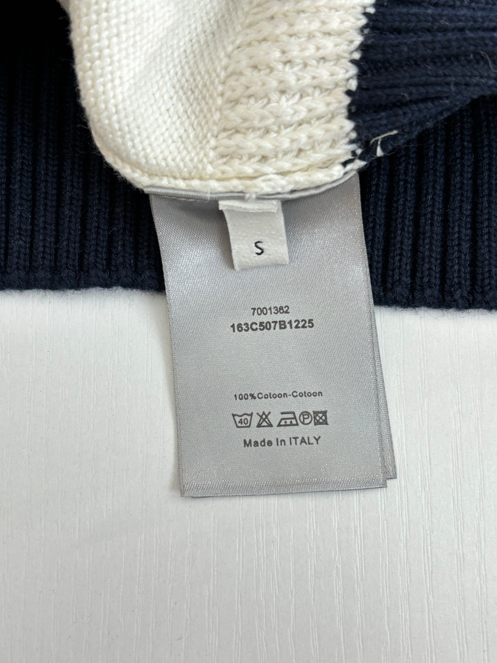 Dior sweater care label on cream-and-navy ribbed knit cuff