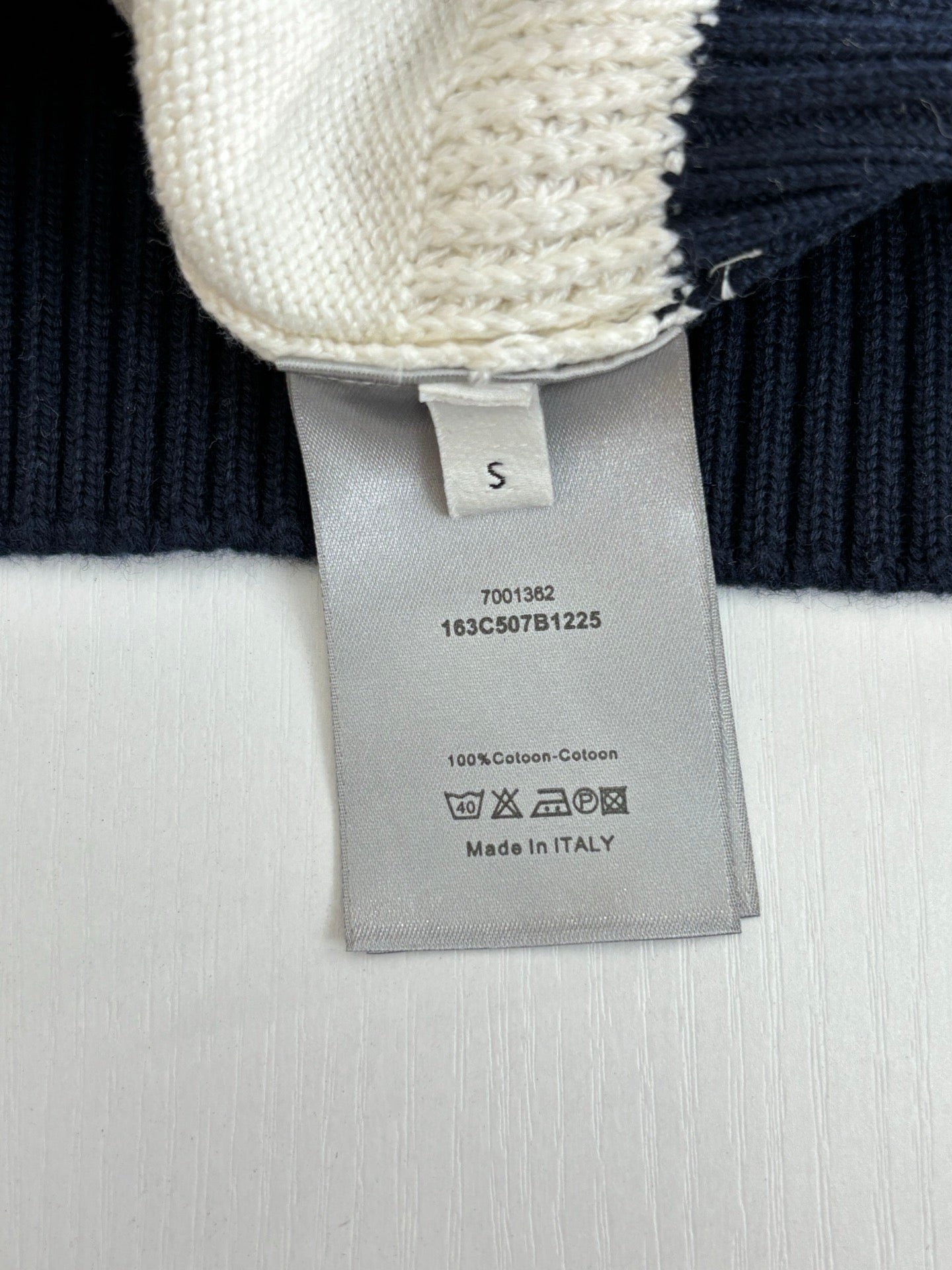 Dior sweater care label on cream-and-navy ribbed knit cuff
