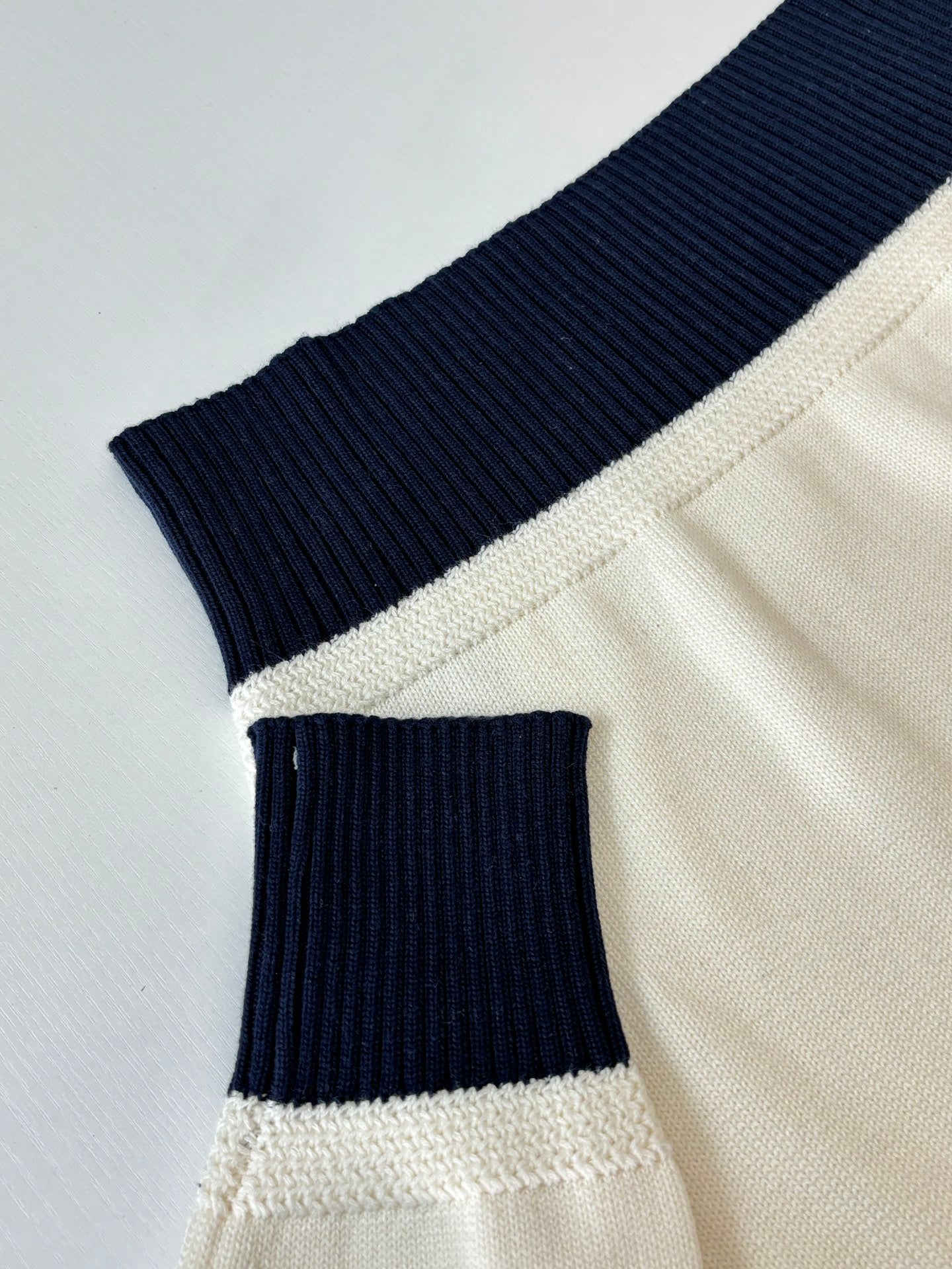 Dior sweater hem detail with cream knit and navy/black ribbed cuff