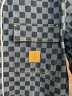 Close-up of checkered shirt chest pocket with brown fabric brand label