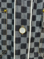 Close-up of checkered shirt front with gold-tone snap buttons and trim seams