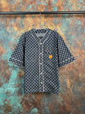 Checkered short-sleeve button-up shirt with dark trim and patch chest pocket