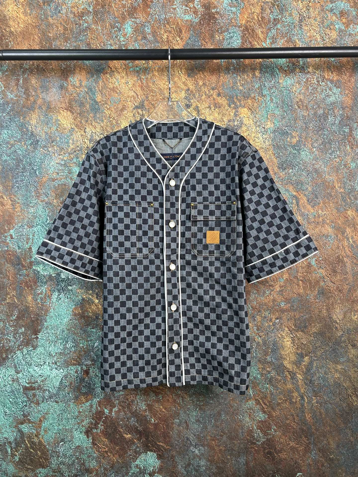 Checkered short-sleeve button-up shirt with dark trim and patch chest pocket