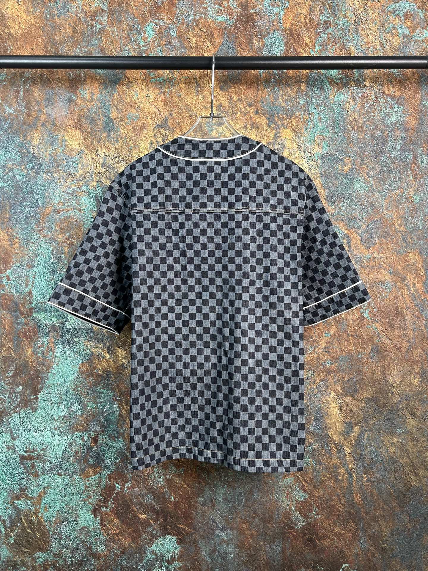 Checkered short-sleeve button-up shirt with striped cuffs and dark buttons