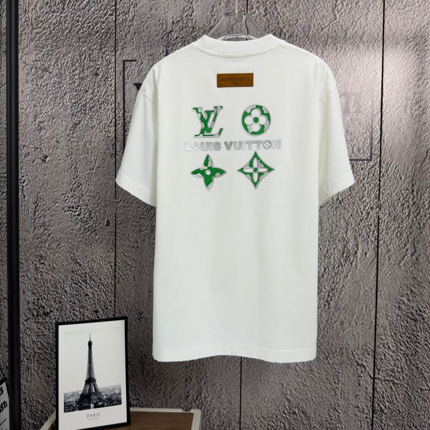White short-sleeve T-shirt with green and gold logo graphic on back