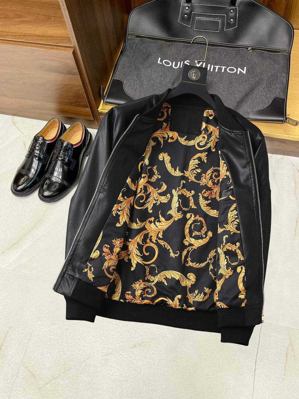 Black leather jacket back with ornate gold baroque-style lining print