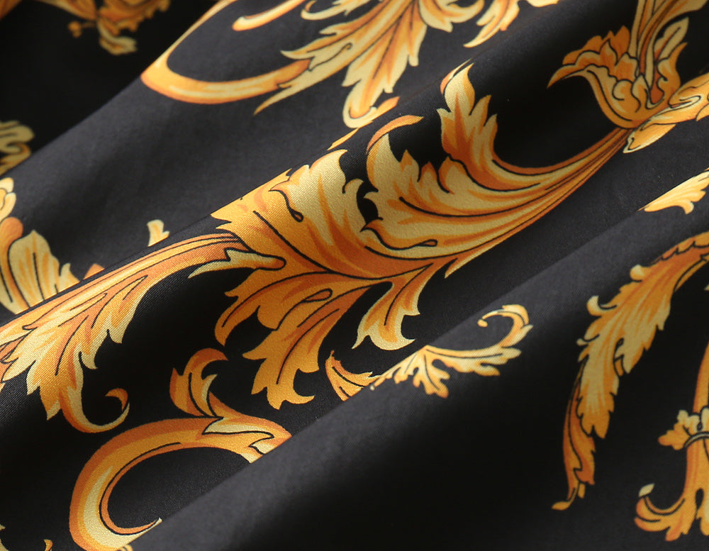 Gold and orange baroque-style scroll pattern on black fabric lining