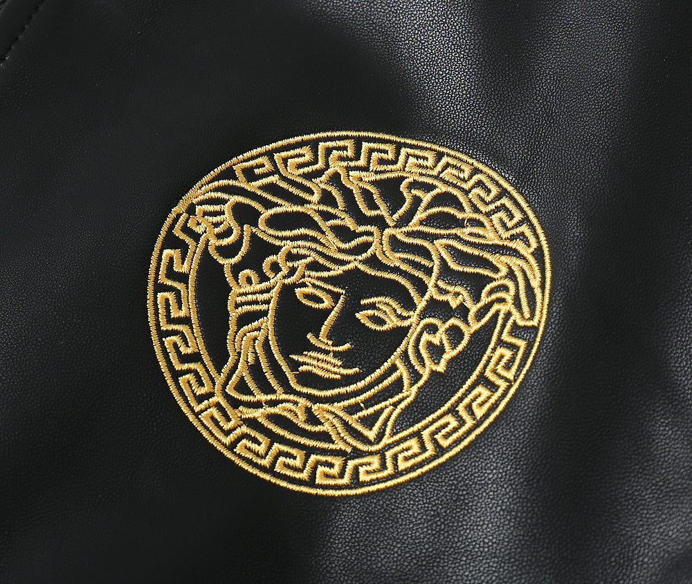 Black leather bomber jacket close-up of gold medallion emblem on the chest